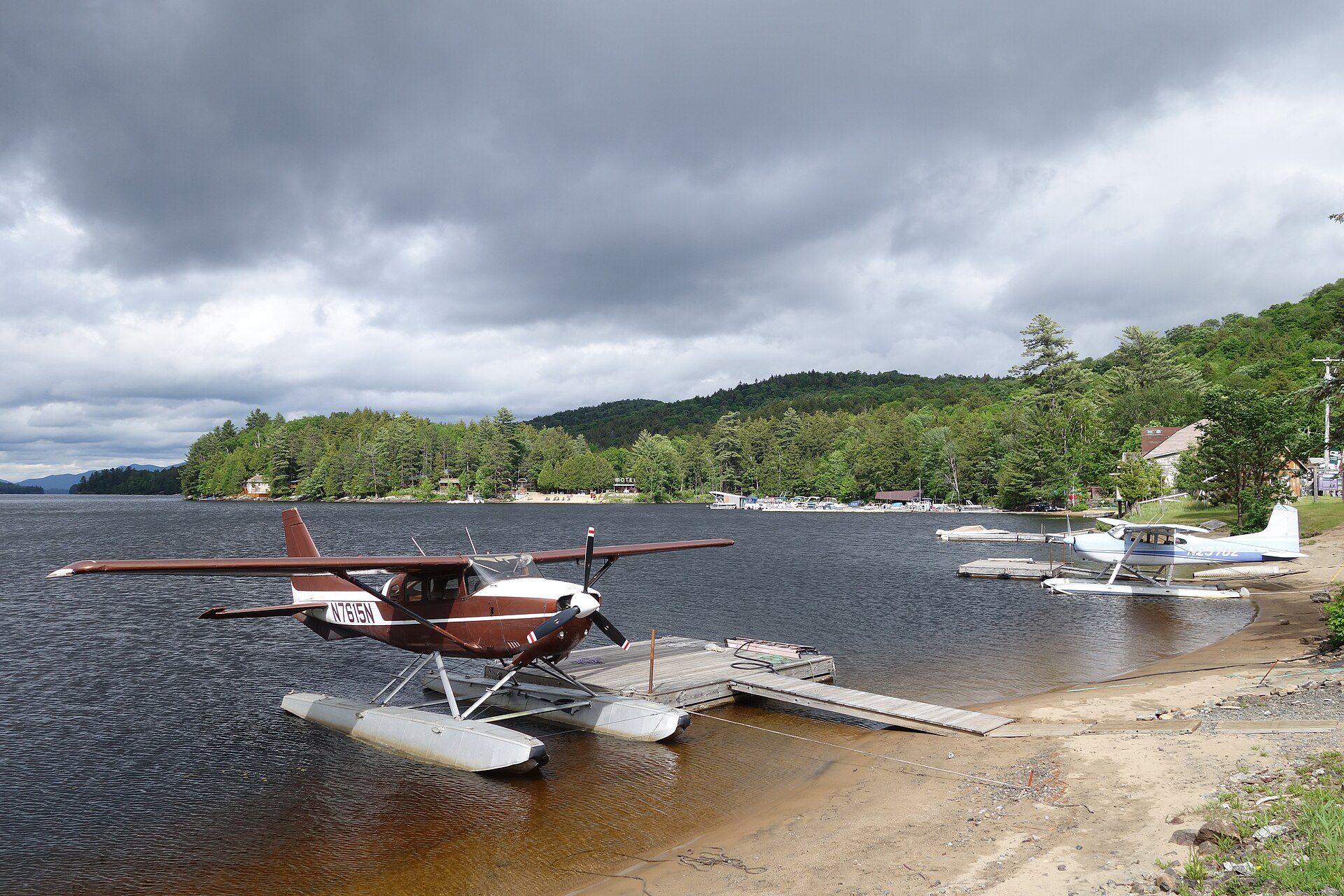 Two floatplanes at a lakeside seaplane base